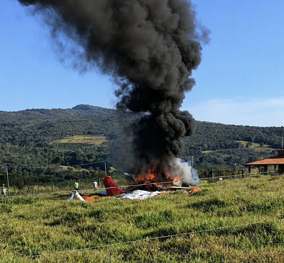 Avião pega fogo e cai em área de mata na RMBH; piloto sobrevive de paraquedas