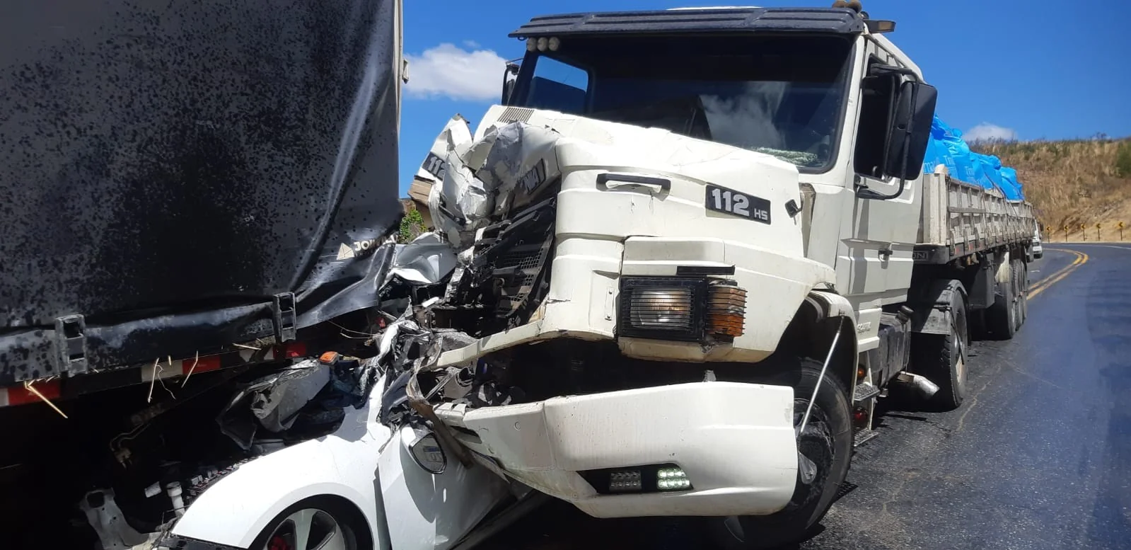 Família sai praticamente ilesa após carro ficar prensado entre carreta e caminhão em MG